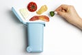Organic waste, trash can and female hand on white background, concept of garbage sorting Royalty Free Stock Photo