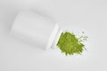 Organic wheatgrass powder in white plastic jar Royalty Free Stock Photo