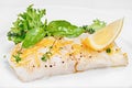 Organic white fish fillet cooked with fresh green salad leafs and lemon Royalty Free Stock Photo
