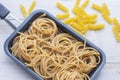 Organic whole wheat bunch of raw italian spaghetti pasta on a white table background, selective focus. Royalty Free Stock Photo