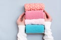 Organization and order. Women`s hands hold a box of neatly folded knitted clothes. Top view