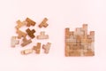 Organization and order. Wooden puzzle pieces are stacked correctly and chaotically scattered in disarray on a pink background