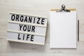 `Organize your life` on a lightbox, clipboard with blank sheet of paper on a white wooden surface, top view. Flat lay, overhead, Royalty Free Stock Photo