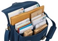 Organized blue messenger bag with multiple compartments containing envelopes, cards, and small gift boxes Royalty Free Stock Photo
