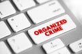 Organized Crime is a continuing criminal enterprise that works to profit from illicit activities, text concept button on keyboard