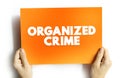 Organized Crime is a continuing criminal enterprise that works to profit from illicit activities, text concept on card Royalty Free Stock Photo