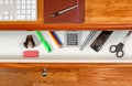 Organized desktop and open drawer with wooden floor underneath Royalty Free Stock Photo