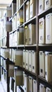 Organized office space with rows of document storage boxes on shelves for efficient filing system. Records and Information