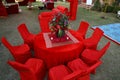 Organized red table and chairs decorated with flower centerpiece, luxury sitting arrangement ready for the guests on a grassland Royalty Free Stock Photo