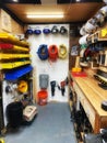 Organized shop storage area featuring bins of small parts, safety helmets, and cords wrapped up.