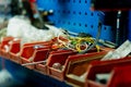 Organized workshop storage area showing red plastic bins holding wires Royalty Free Stock Photo