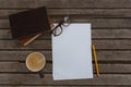 Organizer, coffee, spectacles, pencil and paper on wooden plank