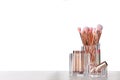 Organizer with different makeup brushes and lipsticks on white table Royalty Free Stock Photo