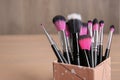 Organizer with makeup brushes on wooden table Royalty Free Stock Photo