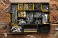 Organizer with many different fasteners and wrenches on wooden table, flat lay Royalty Free Stock Photo