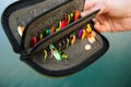 Organizer with a set of artificial lures for fishing in the hands of a fisherman. Royalty Free Stock Photo