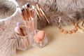Organizer with set of professional makeup brushes and accessories on wooden table Royalty Free Stock Photo