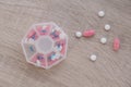 Organizer weekly shots Closeup of medical pill box with doses of tablets for daily take medicine with white pink drugs