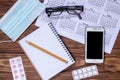 Organizing doctor`s workplace. Wooden table with mask, glasses, calendar and other medical objects Royalty Free Stock Photo