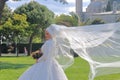 Oriental beauty in a white dress of the bride with a waving veil