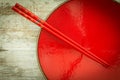 Oriental ceramic plate and chopsticks in red Royalty Free Stock Photo