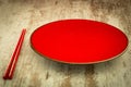 Oriental ceramic plate and chopsticks in red Royalty Free Stock Photo