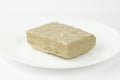 Oriental dessert - halva from sunflower seeds with sugar on a white plate Royalty Free Stock Photo