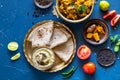 Oriental food Indian paneer sabji with chapati and chutney sous. indian cuisine. Indian Curry in copper brass with ingredients in