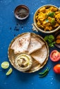 Oriental food - Indian paneer sabji with chapati and sauce. indian cuisine. Indian Curry in copper brass with ingredients in blue