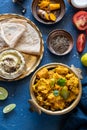 Oriental food - Indian paneer sabji with chapati and sauce. indian cuisine. Indian Curry in copper brass with ingredients in blue