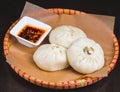 Oriental Fried Dim Sum with Minced Meat also known as Gyoza, Dim Sum, Jiaozi or Momo on a Banana Leaf with Spicy Sauce Close Up. Royalty Free Stock Photo