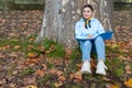 Oriental girl sitting under a tree with a blue folder in her hands, Austria Royalty Free Stock Photo