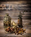 Oriental lantern and mill. Raisins and dates on wooden background