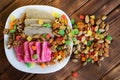 Oriental sweets: unusual pink and traditional gray halva in a white plate next to candied fruits, pistachios, almonds and walnuts