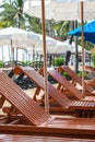 The oriental tropical beach resort. Wooden beach beds. Umbrellas at poolside with beach view