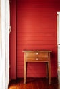 Oriental vintage wooden drawers desk in old house with red wall