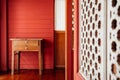 Oriental vintage wooden drawers desk in old house with red wall