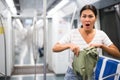 Oriental woman amazed by theft from her bag in subway car Royalty Free Stock Photo