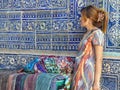 Oriental women in front of a decorated ancient ceramic wall to Khiva in Uzbekistan.