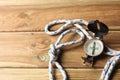 An orientation compass and a sailing rope rest on a wooden table with copy space for your text