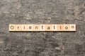 Orientation word written on wood block. Orientation text on cement table for your desing, concept Royalty Free Stock Photo