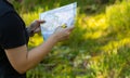 Orienteering athlete running through a summer forest with a map and compass. Royalty Free Stock Photo