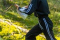 Orienteering athlete running through a summer forest with a map and compass. Royalty Free Stock Photo