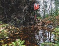 An orienteering control in forest hanging above a water puddle