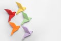 Origami art. Colorful handmade paper birds on white background, flat lay. Space for text Royalty Free Stock Photo