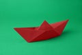 Origami art. Red paper boat on green background Royalty Free Stock Photo