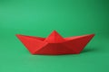 Origami art. Red paper boat on green background Royalty Free Stock Photo