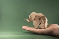 Origami baby elephant made of craft paper on green background, paper and forest conservation concept, save paper save the forest, Royalty Free Stock Photo