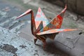 An origami bird made of folded paper sits on the ground, Depict an origami crane crafted from binary permutations, AI Generated Royalty Free Stock Photo