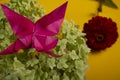 Origami butterfly on a green bush in a basket on a colored background beautiful bouquet studio close shot handmade